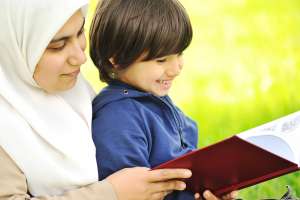 Mãe Muçulmana e seu filho na natureza, lendo juntos